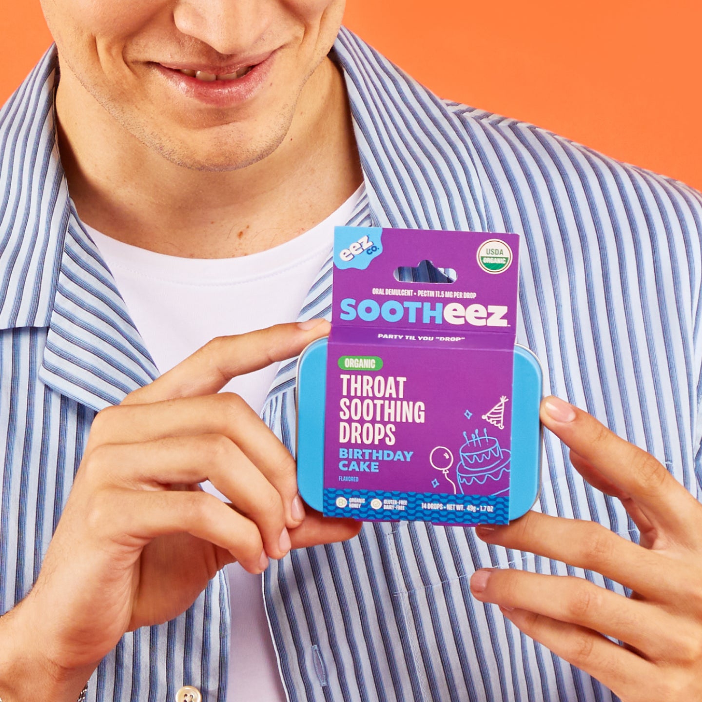 Person holding a tin of Sootheez Throat Soothing Drops